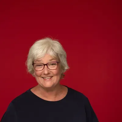 Porträt von Inken Kuhn, sie lächelt und trägt eine Brille.